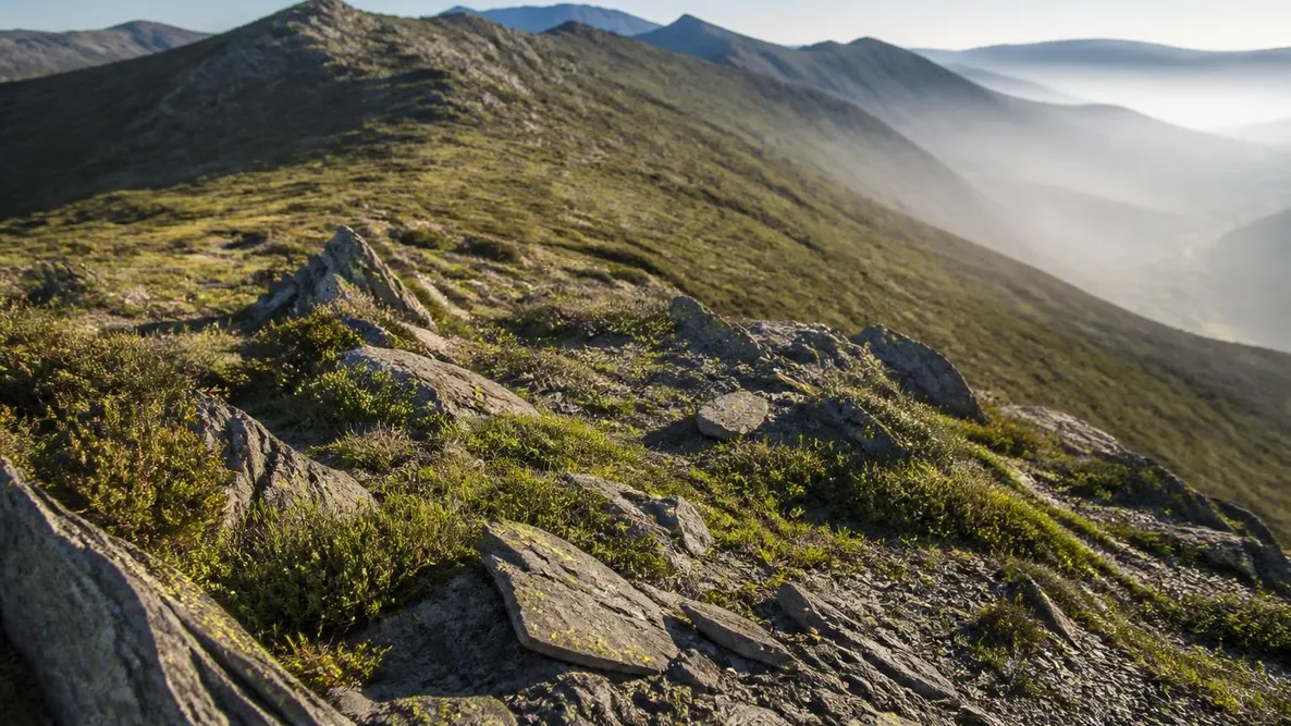 La ligne de crête de la Costiera au-dessus de la vallée du Golo, maquis et versants nus sous un ciel de juin