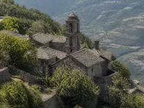 Les maisons de schiste du hameau de Panicale serrées en contrebas du village, avec le clocher de l'église au milieu