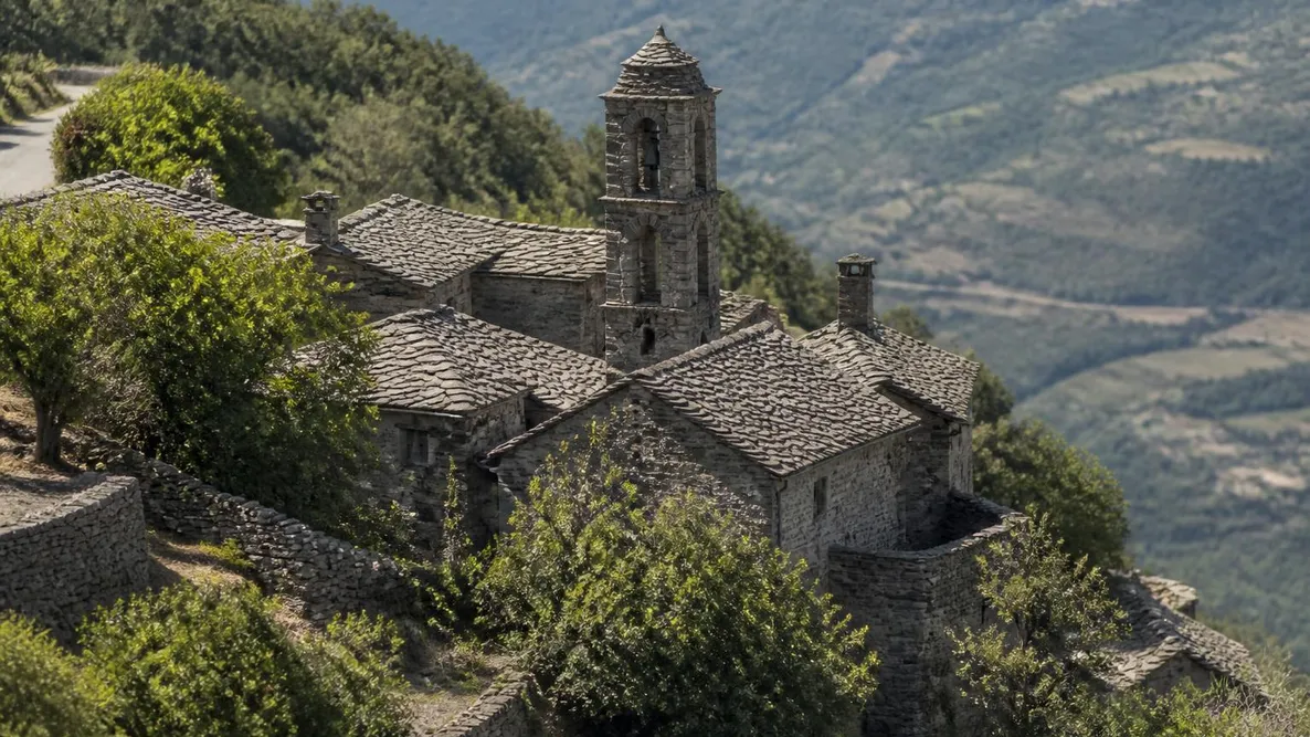 Les maisons de schiste du hameau de Panicale serrées en contrebas du village, avec le clocher de l'église au milieu